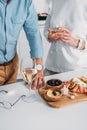 partial view of senior couple drinking wine and eating delicious snacks Royalty Free Stock Photo