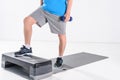 partial view of senior man with dumbbells exercising on stepper Royalty Free Stock Photo