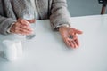 partial view of senior woman with pill and glass of water in hands sitting at table alone at home Royalty Free Stock Photo