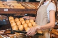 partial view of shop assistant arranging loafs of bread