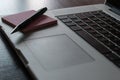 Partial view of a silver keyboard of a laptop with a pink post-it notes and a pencil on a dark wood desk Royalty Free Stock Photo