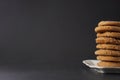 Partial view of a stack of gingerbread cookies on a white plate with a black background