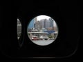 A partial view of Sydney riverside waterfront city from an interior silhouette of a submarine window