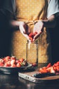 partial view of woman in apron putting strawberries in jar Royalty Free Stock Photo