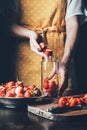 partial view of woman in apron standing at table and putting strawberries Royalty Free Stock Photo