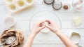 Partial view of woman cracking egg in bowl while cooking on table.