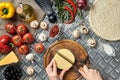 Partial view of woman cutting cheese while cooking homemade italian pizza