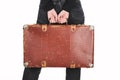 Partial view of woman in jeans holding vintage leather suitcase isolated on white. Royalty Free Stock Photo