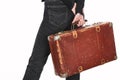 Partial view of woman in jeans holding vintage weathered suitcase isolated on white. Royalty Free Stock Photo