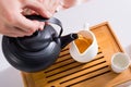 partial view of woman pouring tea into jug while having tea ceremony