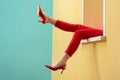 partial view of woman in red pants and shoes outstretching legs out decorative window Royalty Free Stock Photo