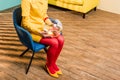 partial view of woman in retro clothing with golden fish in aquarium sitting on chair at colorful apartment, doll Royalty Free Stock Photo