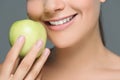 partial view of woman with white teeth and fresh apple