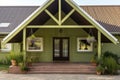 partial view of wooden gabled entrance in an olive green farmhouse