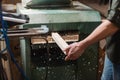 partial view of woodworker sawing plank