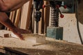 partial view of woodworker using electric drill on wood
