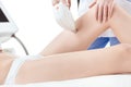 Partial view of young woman receiving laser hair removal epilation on thigh isolated on white Royalty Free Stock Photo