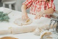 Partially blurred hands of little girl cut out Christmas tree gingerbread cookies from rolled dough in white kitchen Royalty Free Stock Photo