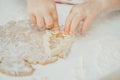 Partially blurred hands of little girl cut out Christmas tree gingerbread cookies from rolled dough in white kitchen Royalty Free Stock Photo