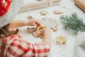 Partially blurred hands of little girl cut out Christmas tree gingerbread cookies from rolled dough in white kitchen Royalty Free Stock Photo