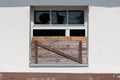 Partially boarded window with broken glass and dilapidated wooden frame at abandoned building of old military complex Royalty Free Stock Photo