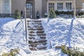 Partially cleared steps in snowy yard - concrete steps climb steeply uphill from street to house and look dangerous