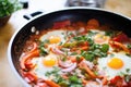 partially cooked shakshuka, eggs just added, yolks intact