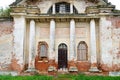 Partially destroyed facade of an ancient building with boarded up windows and doors