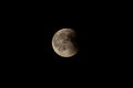 Partially eclipsed full moon, long shot, black sky