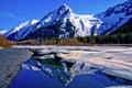 A Partially Frozen Lake with Mountain Range Reflected in the Partially Frozen Waters of a Lake in the Great Alaskan Wilderness. Royalty Free Stock Photo