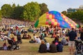 A partially inflated hot air balloon in the middle of a crowd