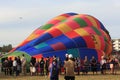 A partially inflated hot air balloon, in the middle of a crowd