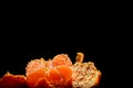 Partially peeled tangerine on a black background is close