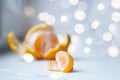 Partially peeled tangerine and tangerine slices, on a light background, with a bokhe of lights. Royalty Free Stock Photo