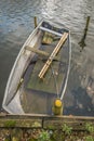 Partially sunken steel rowing boat with oars