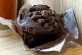 Partially unwrapped chocolate muffin with chocolate chips next t Royalty Free Stock Photo