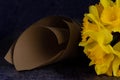 A partially visible bouquet of Narcissuses is lying beside a paper cone Royalty Free Stock Photo