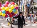 A participant in the annual Adloyada carnival goes with a large bunch of inflated colored balls in Nahariyya, Israel