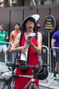 Participant dressed as female standing by bike looking at a map at the Gay Pride Parade, London 2018.