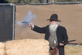 Participant dressed in period cowboy costume, portraying gunfig