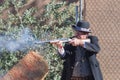 Participant dressed in period cowboy costume, portraying gunfig