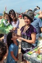 The participant of the Purim festival dressed in fabulous costume, puts a drawing on the girl`s face in Caesarea, Israel