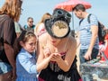 The participant of the Purim festival dressed in fabulous costume, puts a drawing on the girl`s hand in Caesarea, Israel