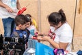 The participant of the Purim festival puts a drawing on the boy`s hand in Caesarea, Israel