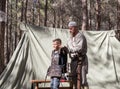 The participant of the reconstruction `Viking Village` Helps the visitor to wear armor in the camp in the forest near Ben Shemen i