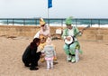 Participants of festival dressed as clowns playing stringed inst