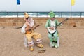 Participants of festival dressed as clowns playing stringed inst