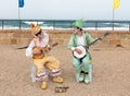 Participants of festival dressed as clowns playing stringed inst