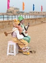 Participants of festival dressed as clowns playing stringed inst