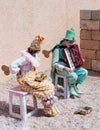 Participants of festival dressed as clowns playing stringed inst